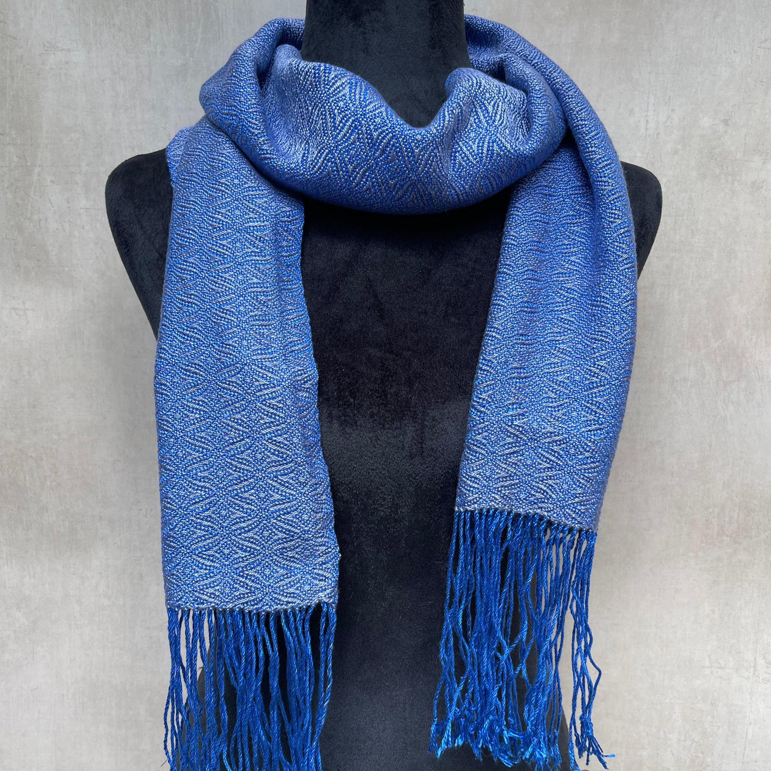 Bluberry color tencel scarf with fringes on a light gray background